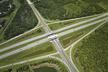 Aerial view of freeway overpass junction with fast moving traffic cars and trucks. Interstate transportation infrastructure in USA Aerial view of freeway overpass junction with fast moving traffic cars and trucks. Interstate transportation infrastructure in USA